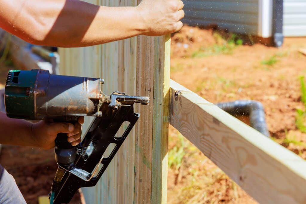 using an air nail gun a man constructs portions o 2023 11 27 05 08 00 utc 2 No.1 Best in Fence Repair in Plano TX- Spring Creek Fence
