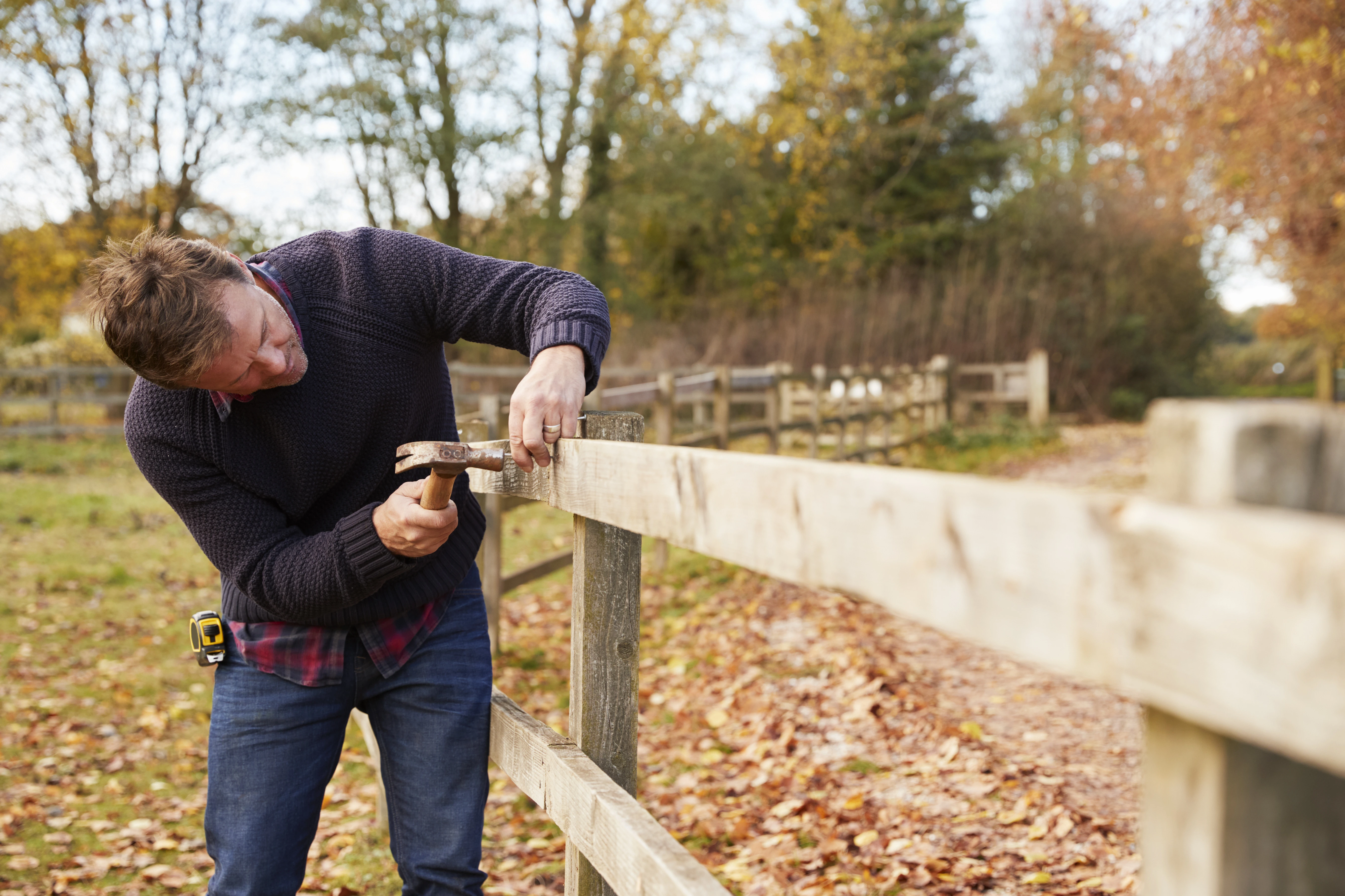 A man working with fence repair tips